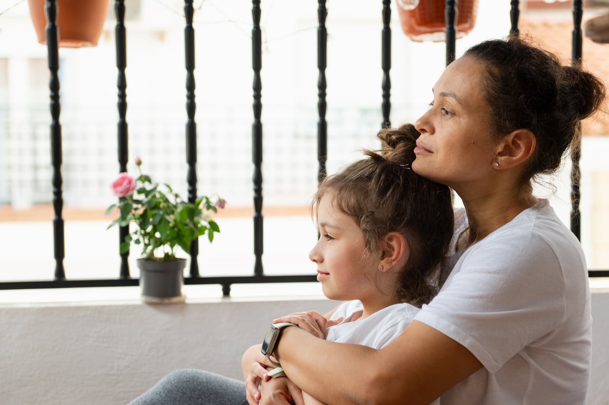 Madre e hija compartiendo un momento íntimo en el balcón