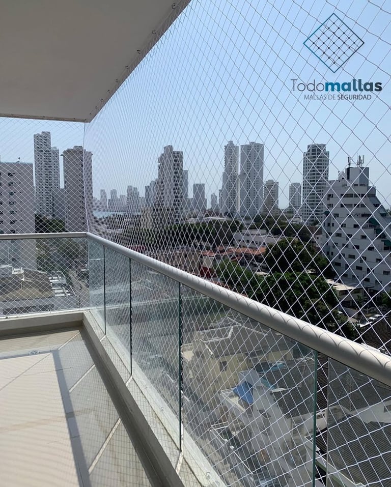 High-rise balcony with mesh safety netting overlooking a city skyline with tall buildings
